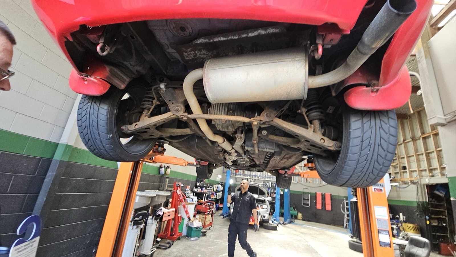Mechanic inspecting a vehicle from underneath — diagnostic work at Precision Automotive